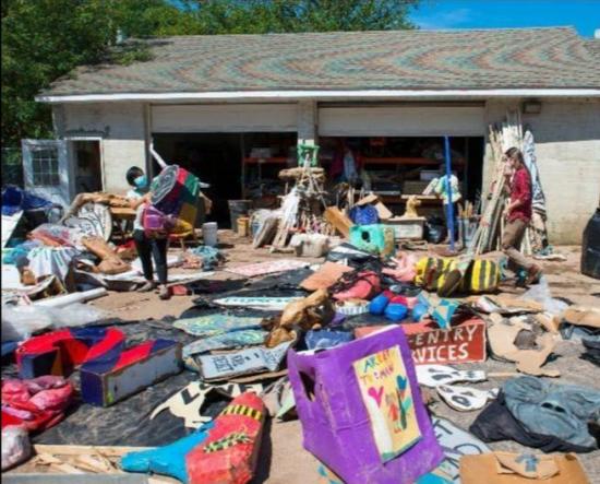 Puppets and other materials are strewn across a parking lot being aired out after the flood. 