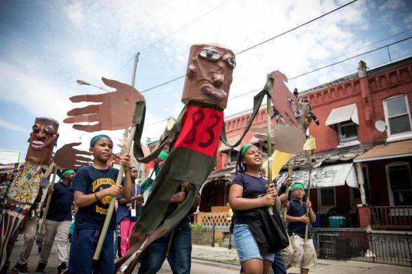 young children march with puppets through their Philadelphia neighborhood