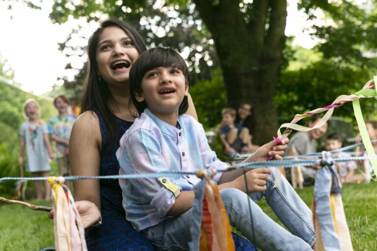 A mother and child with big smile surrounded by ribbon and string
